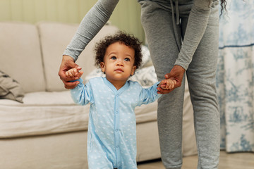 Cropped shot of a mother support her son to walk