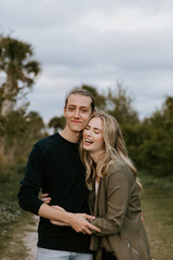 Fototapeta premium Romantic and Loving Young Adult Couple at the Park Looking At Nature and the Horizon for Portrait Pictures