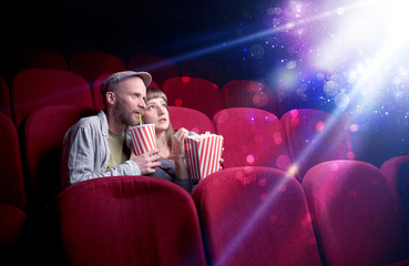 Obraz premium Romantic couple cuddling and watching the miraculous part of the film
