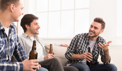 Guys drinking beer, talking and celebrate meeting
