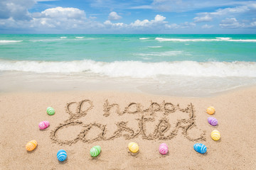 Happy easter lettering background with eggs on the sandy beach - 261349503