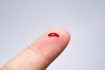 Bleeding blood from the cut finger wound. Injured finger with bleeding open cut wound. Closeup of...