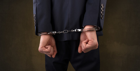 Close now arrested men hand with dark background and handcuffs
