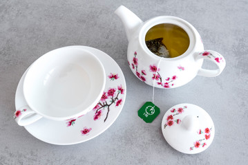 Traditional modern and elegant china tea service with tea bag on the grey table