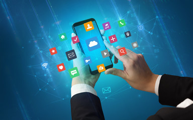 Female hand using smartphone with colorful application icons around