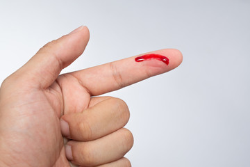 Bleeding blood from the cut finger wound. Injured finger with bleeding open cut wound. Closeup of...