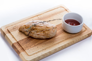 grilled chicken with sauce on a wooden board