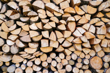 Pile of firewood.prepared to fireplace for the winter and use for cooking,firewood background,Stacks of firewood arranged in a row in the forest.Material for heating the house.Ecological natural fuel.