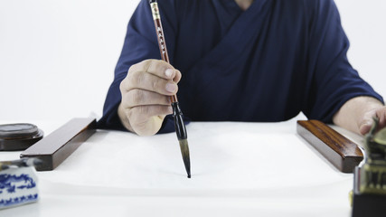 Person hand with brush start drawing calligraphy