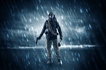 Terrorist in a stormy space with gas mask on his hand and weapons on his arm
