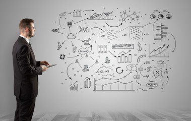 Manager staying and presenting office affairs for someone with graphs, icons reports around
