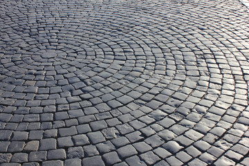 Cobblestone pavement texture and stone pattern of street with sun reflection