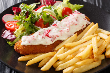 Fototapeta na wymiar fish in breading with a side dish of french fries and fresh salad close-up. horizontal