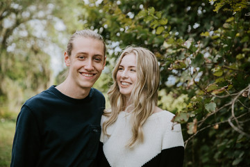 Naklejka premium Young Cute Romantic Beautiful Loving Couple Face to Face Looking into Each Others Eyes Outside in Nature