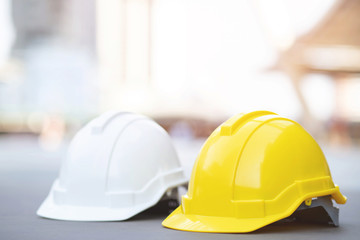 yellow and white hard safety wear helmet hat in the project at construction site building on...