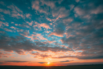 Sunset Sunrise Over Field Or Meadow. Bright Dramatic Sky And Dark Ground. Countryside Landscape Under Scenic Colorful Sky At Sunset Dawn Sunrise. Skyline