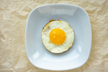 Round fried egg in the plate.