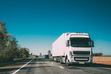 Obraz premium Truck On Country Road. Tractor Unit, Prime Mover, Traction Unit In Motion On Countryside Road In Europe. Business Transportation And Trucking Industry Concept