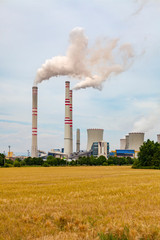 Fototapeta na wymiar Coal power plant polluting environment and chimneys smoking towards the sky.