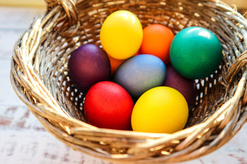 Fototapeta na wymiar pack of colorful easter eggs in vintage basket closeup