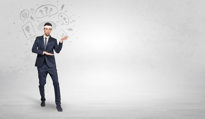 Young businessman in suit fighting with doodled symbols concept
