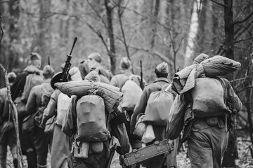 Re-enactors Dressed As World War II Russian Soviet Red Army Soldiers Marching Through Forest In Autumn Day. Photo In Black And White Colors. Soldier Of WWII WW2 Times