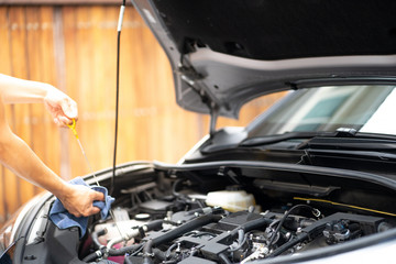 Fototapeta premium Mechanic man working and repair or checking car oil engine in car service center.Automobile metal car engine part details.Concept of modern vehicle motor,Industry,Mechanic and Business.