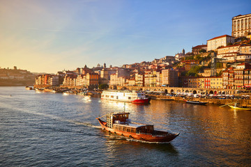 Obraz premium Portugal, Porto old town ribeira aerial promenade view with colorful houses, Douro river and boats.Concept of world travel, sightseeing and tourism