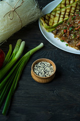 Sesame seeds in a wooden bowl. Roasted sesame seeds. Raw, whole, unprocessed. Natural light. Selective focus. Dark wooden background.