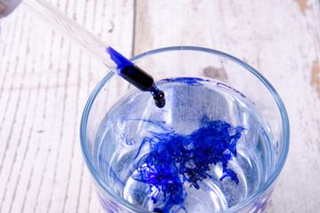 blue ink dropping in a glass of water