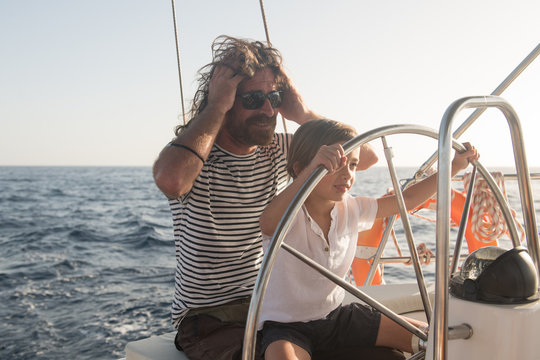 Father and son floating on expensive boat on sea and blue sky in sunny day