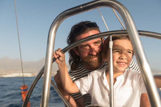 Happy father with children floating on expensive boat on sea and blue sky in sunny day