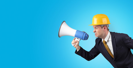 Fototapeta premium Young architect constructor yelling with megaphone and copyspace
