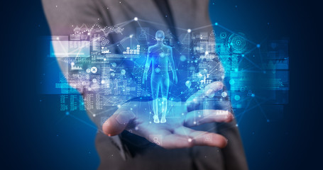 Young person holding hologram projection displaying health related graphs and symbols
