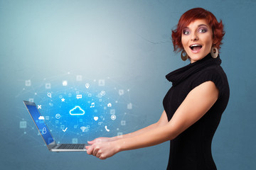 Woman holding laptop projecting notifications, symbols and information based on cloud technology system
