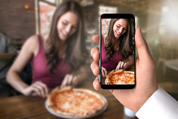 Smartphone recording video, taking picture of friend eating pizza, traveling