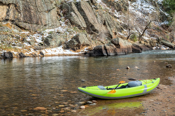 Fototapeta na wymiar inflatable whitewater kayak on a rocky shore of a mountain river