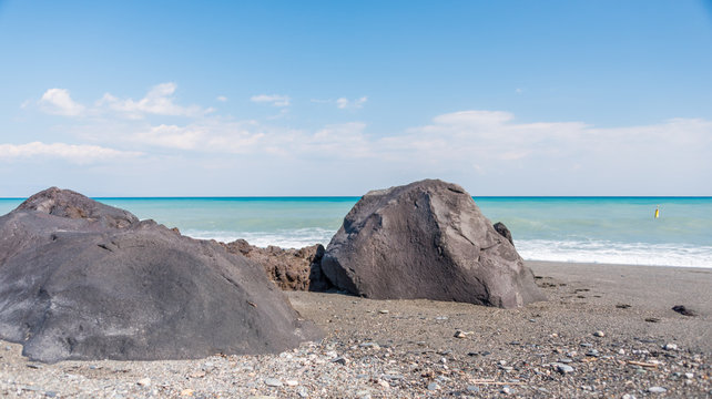 Cloudscape and Volcanic Black Sand Beach and Blue Ionian Sea in Sicily
