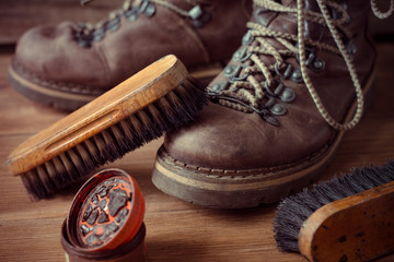 Fototapeta na wymiar Old vintage leather boots with shoe brush on wooden background