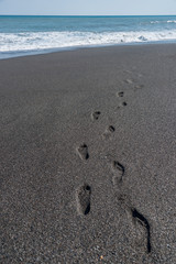 Fototapeta na wymiar Footstep Impressions on a Volcanic Black Sand Beach in Sicily