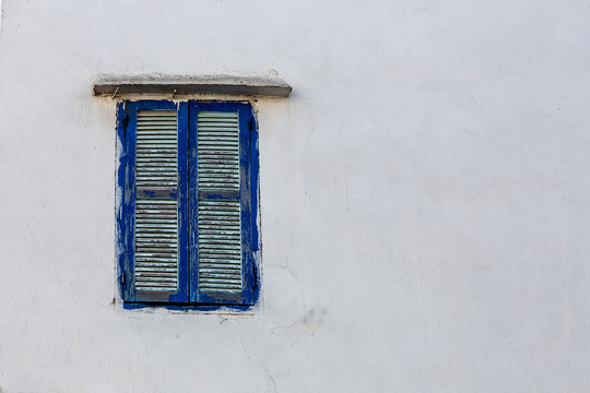 Blue window shutters on white concrete wall of house in Tangier, Morocco