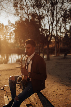 young musician playing the saxophone at sunset