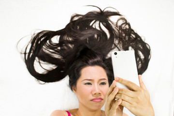 Fototapeta premium Closeup portrait of moody asian women lying on ground with black long hair. acting upset , unhappy,