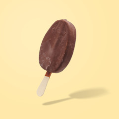 Chocolate ice cream popsicle on a yellow background