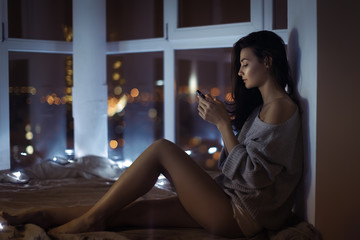 Woman use of mobile phone indoors at night