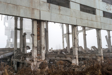 The remains of a large building destroyed in a foggy haze. Background.