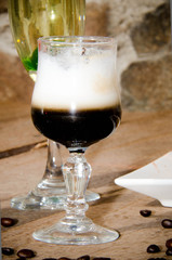 coffee in a glass with crema. on a wooden table decorated with coffee beans