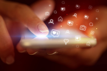 Finger touching phone with social media concept and dark background
