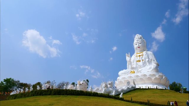 Time lapse of white big Guanyin statue with blue sky