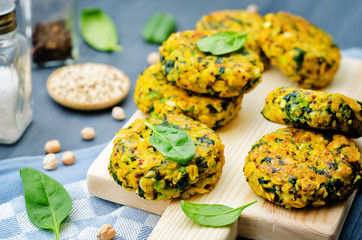 Quinoa spinach chickpeas pumpkin fritters on a wood background